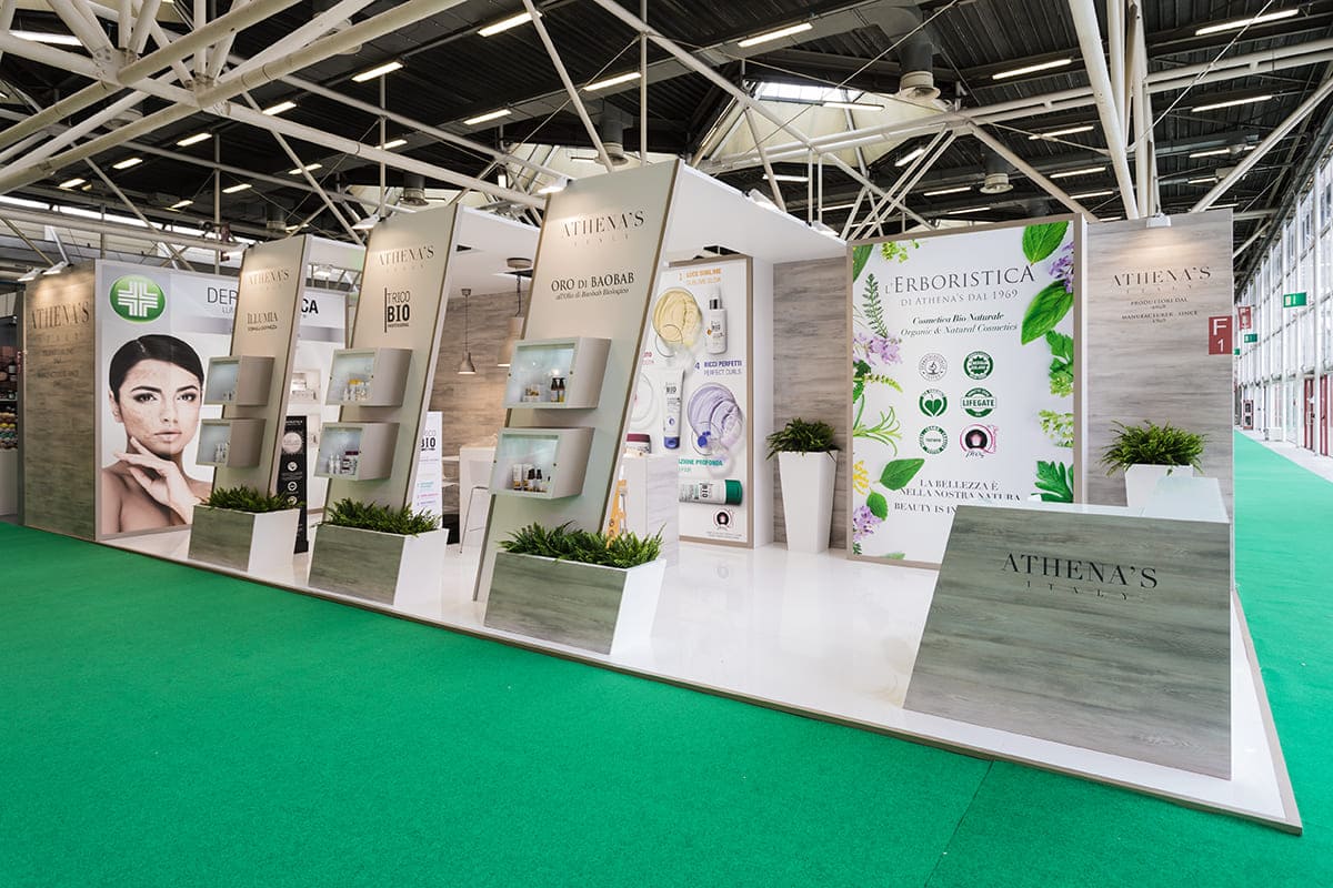 L'immagine raffigura un caso reale di allestimento fieristico: l'allestimento dello stand AthenaS realizzato da Diquadro in occasione di una precedente edizione della fiera Cosmofarma di Bologna.
