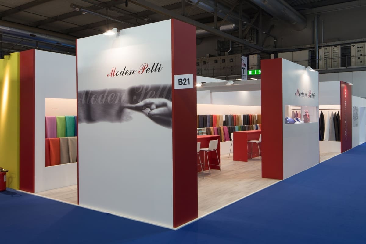 L' immagine raffigura un caso reale di allestimento fieristico: l' allestimento dello stand Moden Pelli realizzato da Diquadro in occasione di una precedente edizione della fiera Lineapelle di Milano. Lo stand è stato allestito su un pavimento in essenza legno tipo rovere nevada che, insieme alle forme rigorose e al colore deciso e puro, ha ricreato un ambiente razionale, rigoroso e moderno, com' è nello stile abituale di Moden pelli.