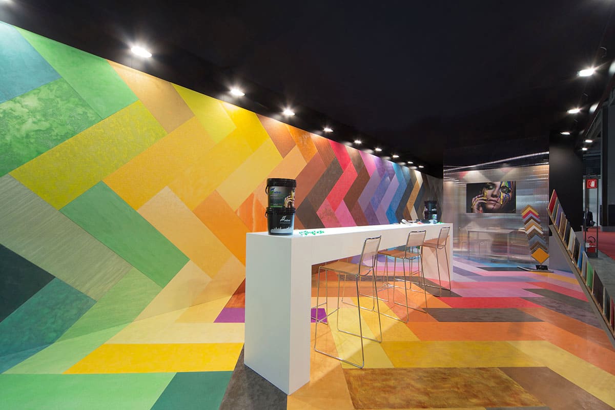 Allestimenti fieristici Madeexpo Milano casi reali: l' allestimento stand realizzato per Saber Color Srl visto dal tavolo accoglienza In quest' ultima immagine l' allestimento dello stand Saber Color realizzato da Diquadro per la fiera Made expo di Milano è mostrato nella sua zona centrale interna. Qui un grande tavolo bianco con piano retroilluminato campeggia come una scultura in uan installazione artistica.