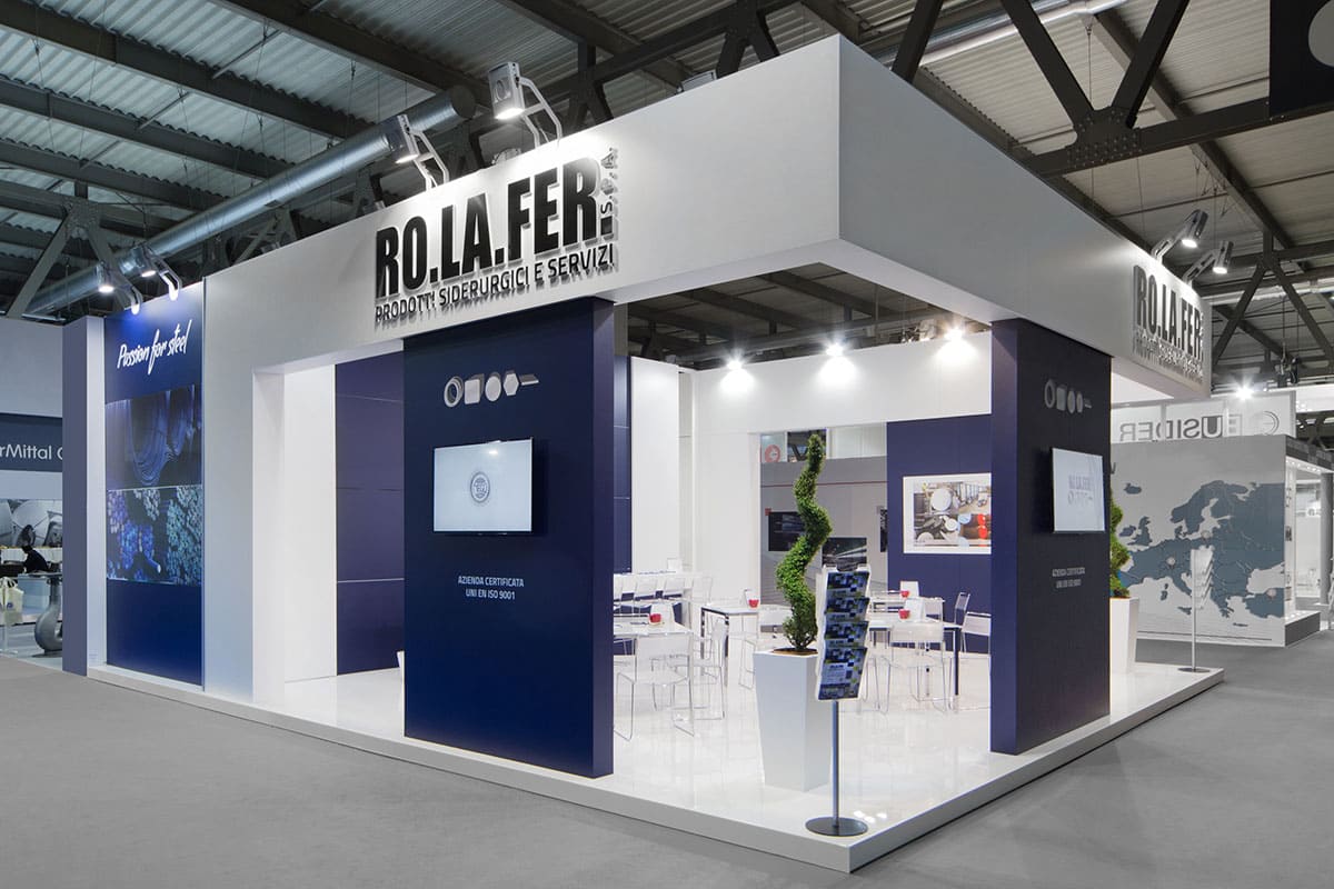 L'immagine raffigura un caso reale di allestimento fieristico: l'allestimento dello stand Rolafer SpA realizzato per Made in Steel di Milano. La foto mostra lo stand ripreso dall'esterno, dall'angolo Sud Ovest.