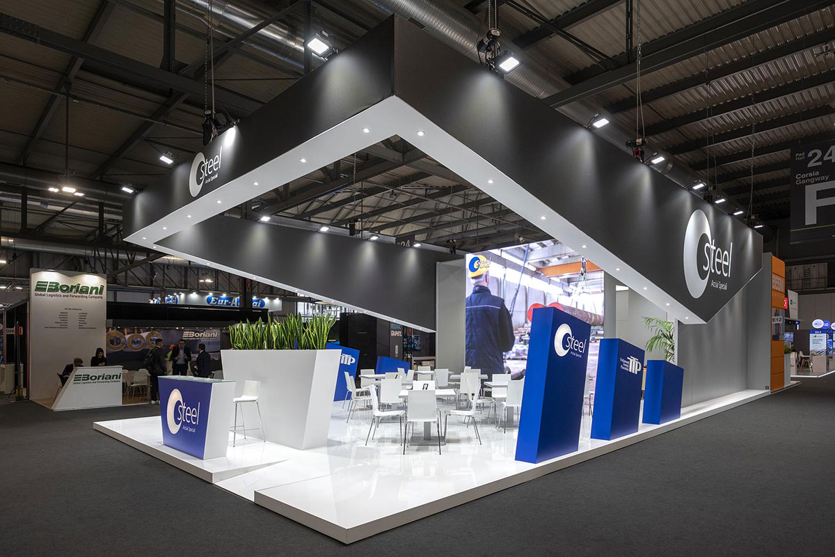 Allestimenti fieristici Made in Steel Milano casi reali: L'allestimento stand realizzato per Steel Acciai L'immagine raffigura un caso reale di allestimento fieristico: l'allestimento dello stand Steel SpA realizzato per Made in Steel di Milano. La foto mostra lo stand ripreso dall'esterno, dall'angolo Sud Est.