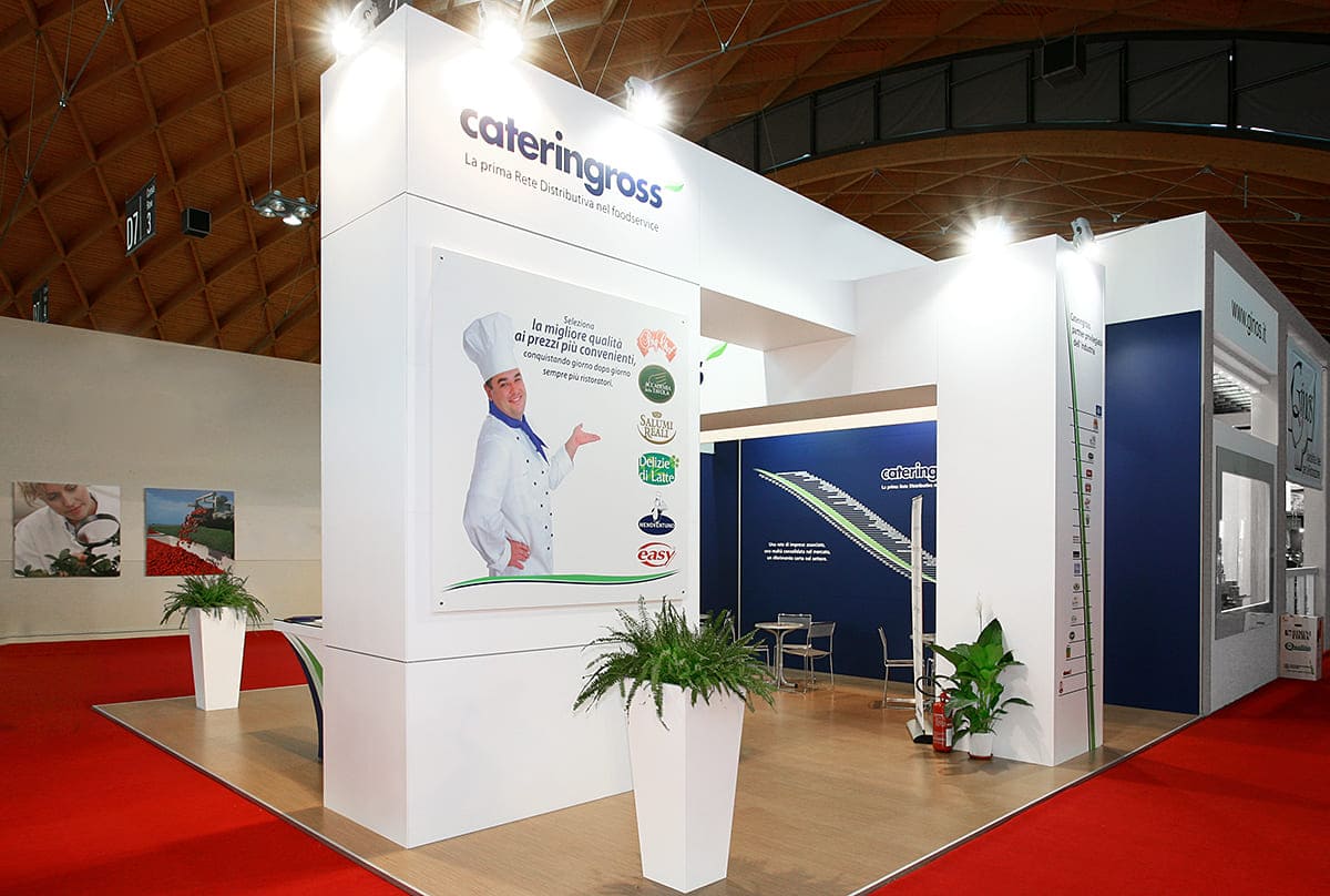 Allestimenti fieristici per Sigep di Rimini casi reali: L'allestimento stand realizzato per Cateringross L'immagine raffigura un caso reale di allestimento fieristico: l'allestimento dello stand Cateringross realizzato per fiera Sigep di Rimini. L'immagine ci mostra una vista esterna dello stand. In particolare, ci mostra l'allestimento ripreso da Sud Est.